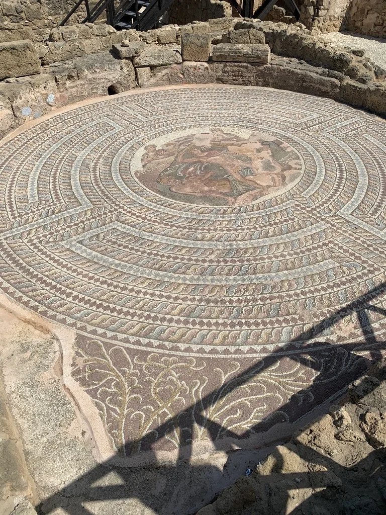 Antyczna okrągła mozaika wśród kamiennych ruin