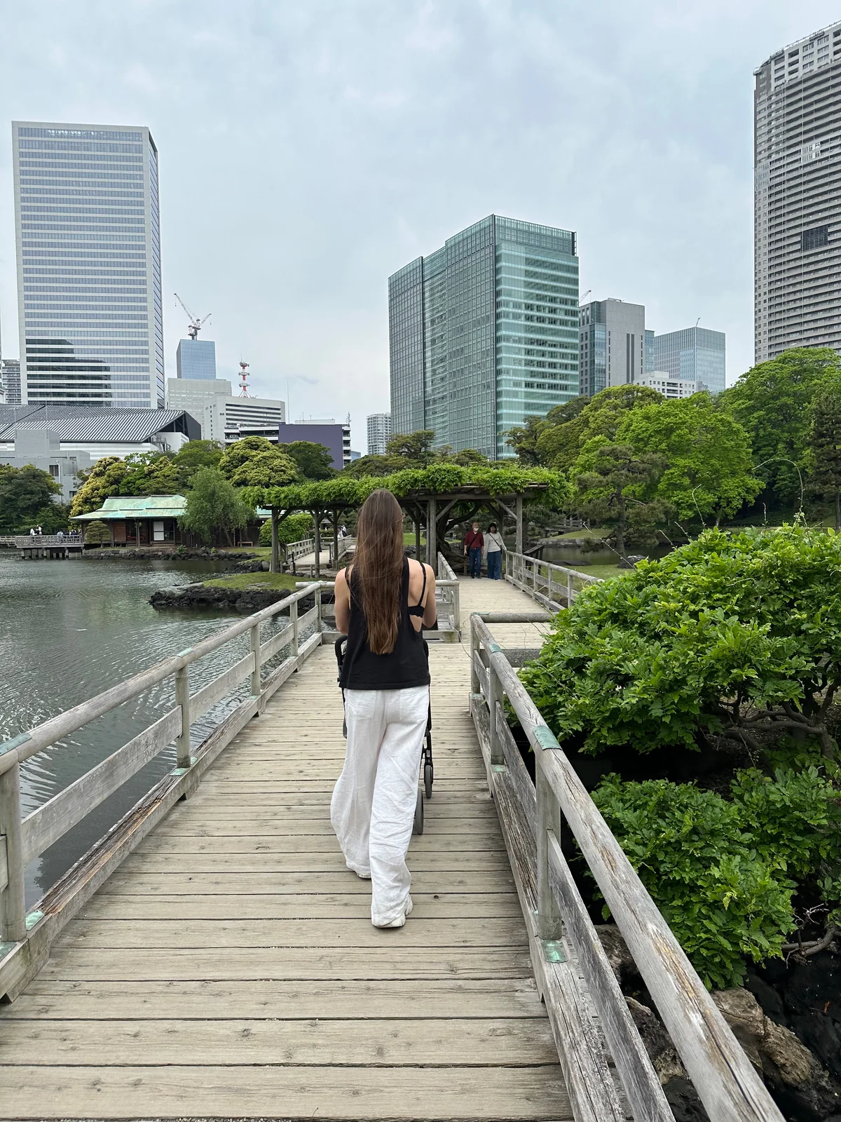 A parent with a stroller, seen from behind in Hama-rikyu Gardens